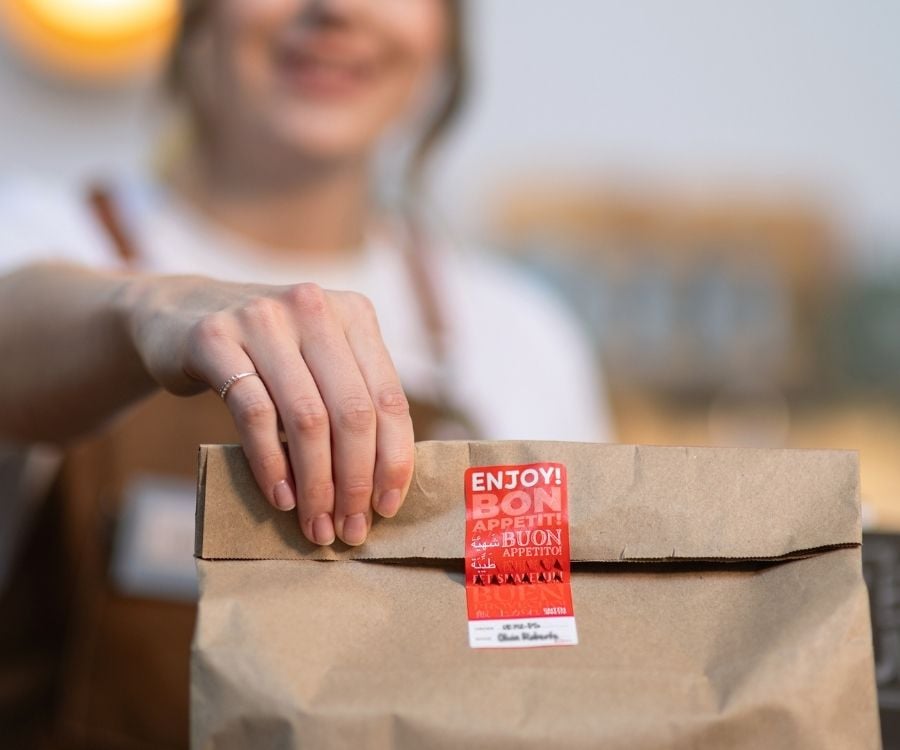 Eine Hand hält ein Lunch-Paket.