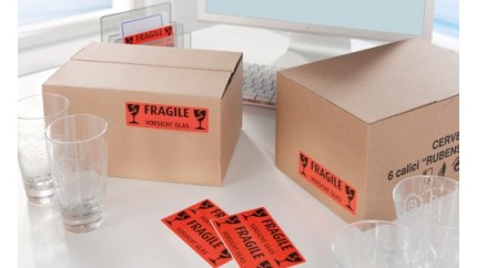 Mehrere Pakete auf denen Aufkleber mit dem Hinweis "Fragile" geklebt sind.