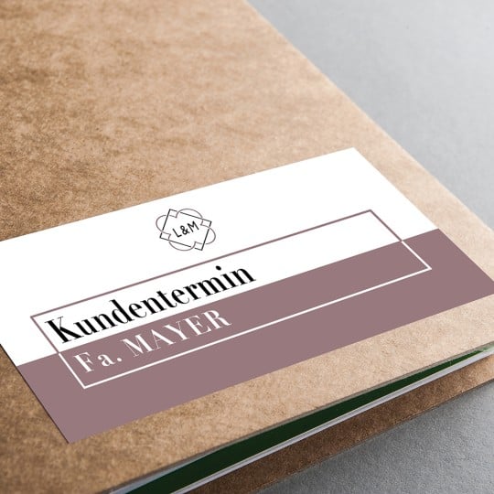 Auf einer Mappe klebt ein bedrucktes Etikett, um die Büroorganisation zu vereinfachen.