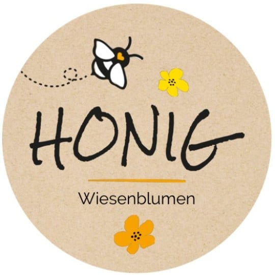 Auf einem runden Honigetikett in Beige, sind Blumen und eine Biene abgebildet. Der Text "Honig Wiesenblumen" steht in der Mitte des Etiketts.