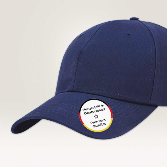 Eine blaue Cap, mit einem runden Textiletikett welches Made in Germany und Premium Qualität zeigt