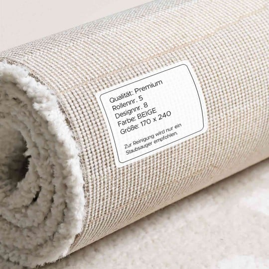 Ein beigefarbener Teppich, der auf der Rückseite ein Textiletikett enthält welches Produktdetails zeigt