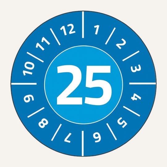 Man sieht eine blaue, runde Prüfplakette. In der Mitte steht die Zahl 25 in Weiß. Im Kreis darum stehen die Zahlen 1 bis 12 in Weiß.