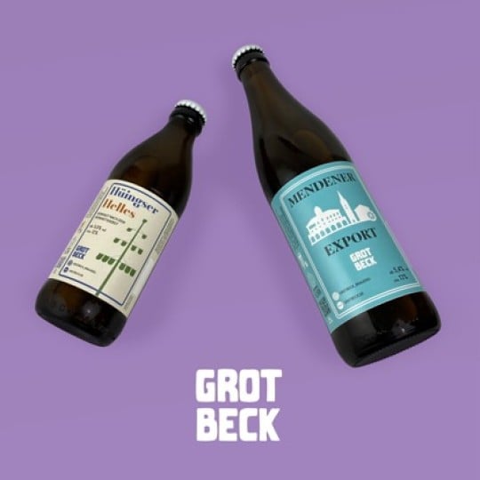 Zwei Bierflaschen mit einem Bieretikett in cremeweiß und blau sind zu sehen.