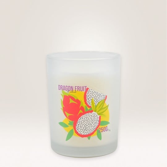 Auf einem Kerzenglas klebt ein Etikett auf dem Dragon Fruit steht und eine Drachenfrucht abgebildet ist.