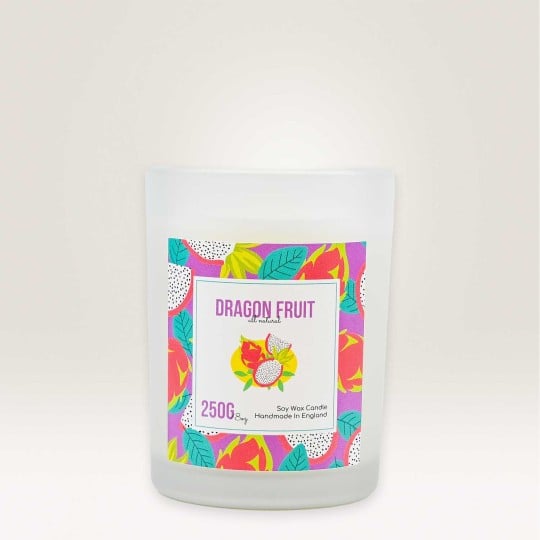 Auf einem Kerzenglas klebt ein Etikett auf dem Dragon Fruit steht und ein Muster aus Drachenfrüchten zu sehen ist.