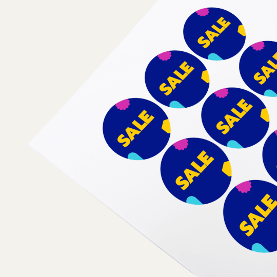 Runde Aufkleber auf Bogen in blauer Farbe mit Aufschrift Sale.