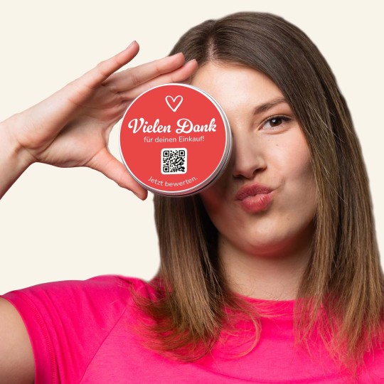 Frau hält Produkt mit rundem Sticker. 