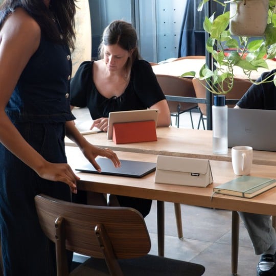 Verschiedene Menschen sitzen an einem Co-Working-Space mit ihren Trigo-Produkten.