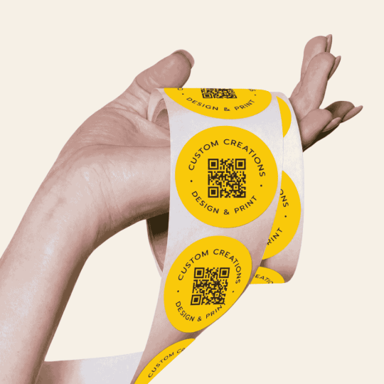 QR-Code Etiketten auf Rolle werden in einer Hand gehalten.