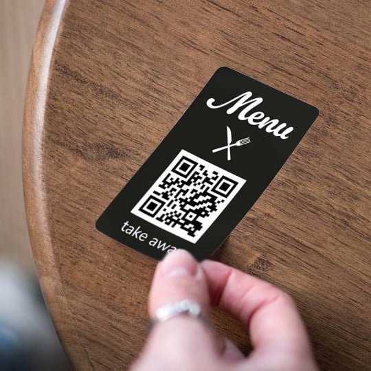 QR Code Menu Sticker klebt auf einem Tisch.