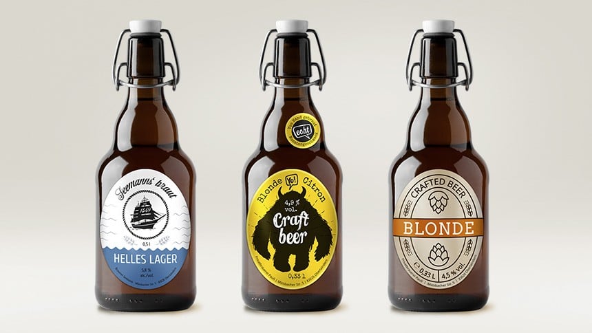 Drei Bierflaschen mit unterschiedlichen Bieretiketten sind zu sehen. Ganz links eine Flasche mit einem blau-weißen Etikett, dann mittig ein gelb-schwarzes Eitkett und ganz rechts ein bronze-farbenes Etikett.
