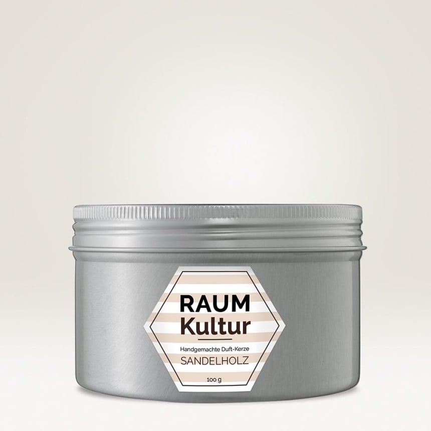 Auf einem silbernen Behältnis klebt ein sechseckiges Kerzenetikett. Auf dem Kerzenetikett steht "Raumkultur handgemachte Duft-Kerze Sandelholz".