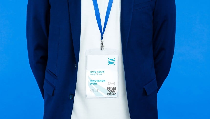 Ein Mann im Anzug trägt ein blaues Lanyard mit einem Namensschild daran befestigt