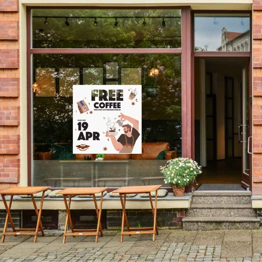 Im Schaufenster klebt ein Fensteraufkleber mit der Info Free Coffee.