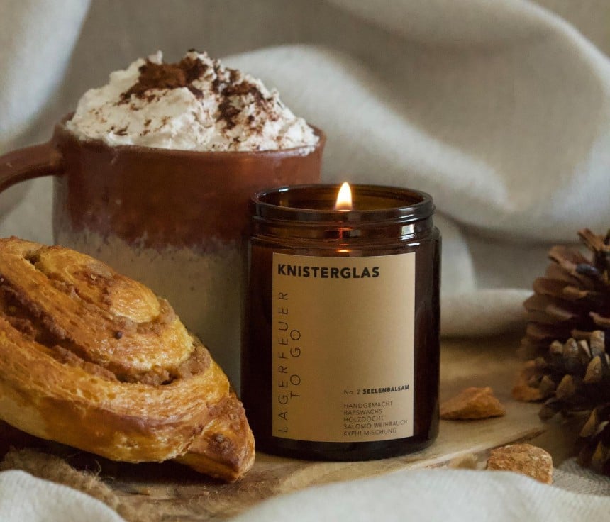 Eine Kerze mit einem Kaffee und Nussschnecke sind zu sehen.