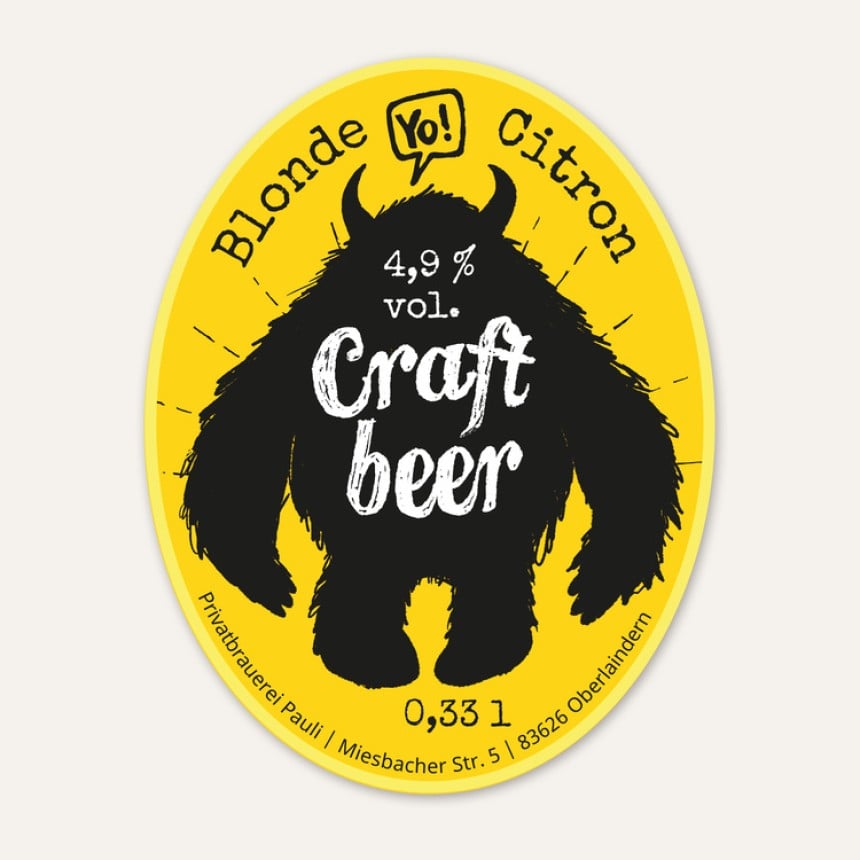 Auf einem ovalen Aufkleber in Gelb ist ein schwarzes Monster abgebildet und es steht "Blonde Citron 4,9% vol. Craft Beer" darauf.
