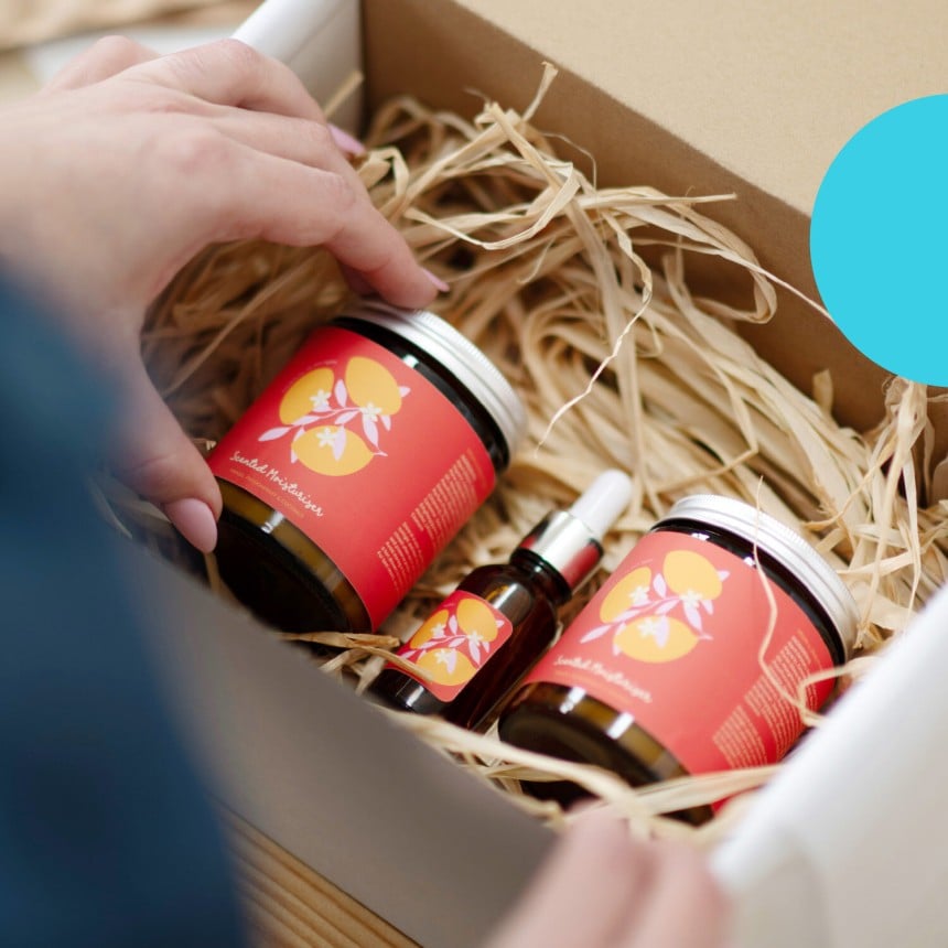 Eine Hand packt ein Glas in eine Packung.