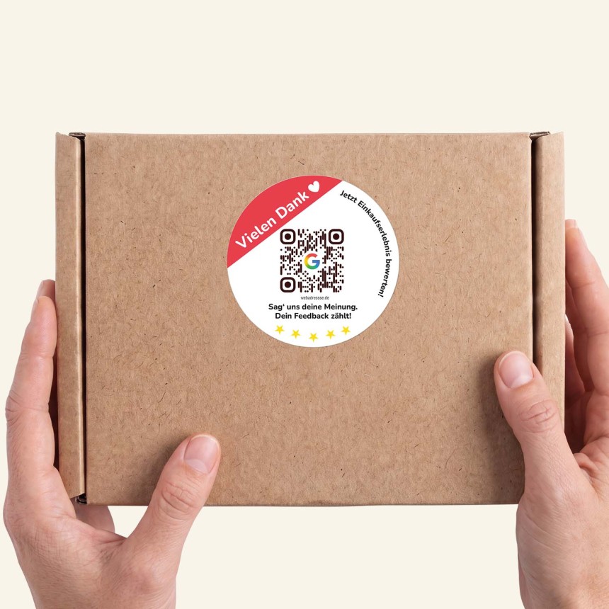Hand hält ein paket mit rundem Sticker.