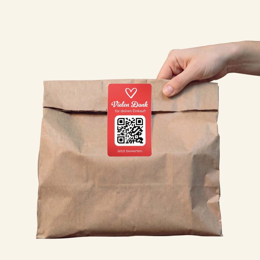 Hand hält eine Food Tüte mit QR Code Sticker.
