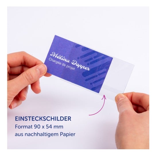 Das Bild zeigt eine Hand, die eine blaue Visitenkarte mit dem Namen 'Mélina Dopper' und dem Titel 'Chargée de projet' hält, zusammen mit einem Text, der darauf hinweist, dass es sich um eine Projektkarte aus nachhaltigem Papier handelt.