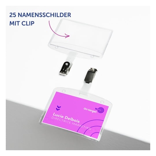 Das Bild zeigt einen klaren Namensschildhalter mit einer Klammer. Es zeigt den Namen 'Lucie Delbois' und den Titel 'DIRECTRICE MARKETING' vor einem violetten Hintergrund. Das Abzeichen ist Teil eines Sets von 25.