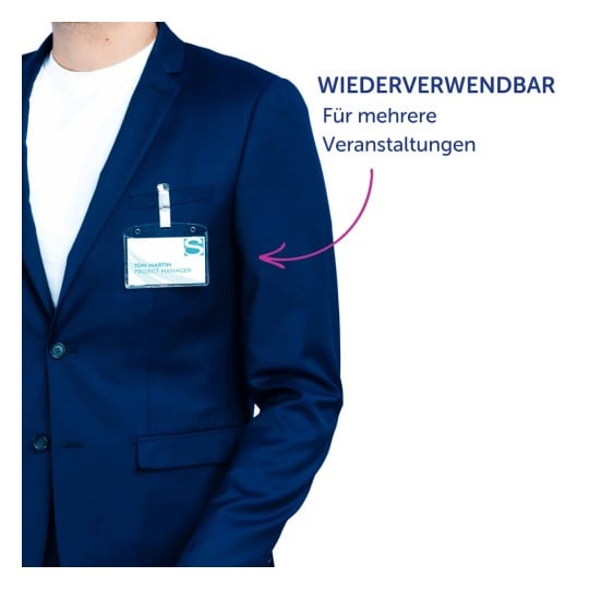Das Bild zeigt eine Person, die einen blauen Blazer trägt, mit einem Namensschild, auf dem 'TOM MARTIN PROJEKTMANAGER' steht. Im Hintergrund sind die Texte 'WIEDERVERWENDBAR' und 'Für mehrere Veranstaltungen' zu sehen.