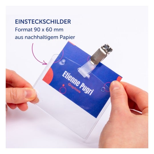 Das Bild zeigt einen Namensschildhalter mit einem Einsatz, der mit 'Etienne Pugri' und 'Graphiste' beschriftet ist. Es hebt die Spezifikationen des Halters hervor, einschließlich seiner Abmessungen und seines Materials.