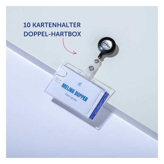 Das Bild zeigt einen Ausweishalter mit einem einziehbaren Rollclip. Er enthält eine Karte mit dem Namen 'MELINA DOPPER' und dem Titel 'Designer.' Der Hintergrund ist schlicht und weiß, mit dem Text '10 KARTENHALTER DOPPEL-HARTBOX.'