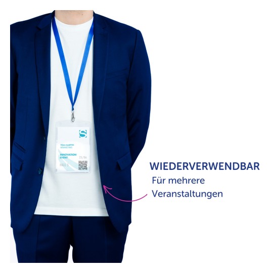 Das Bild zeigt einen Mann in einem blauen Anzug mit einem Namensschild, das darauf hinweist, dass er an einer "Innovationsveranstaltung" teilnimmt. Das Schild zeigt seinen Namen, Tom Martin, sowie einen QR-Code und den Hinweis, dass es für mehrere Veranstaltungen wiederverwendbar ist, hervorgehoben mit deutschem Text.