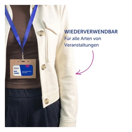 Oberkörper trägt eine cremefarbene Jacke, ein blaues Schlüsselband und ein Namensschild mit der Aufschrift „Mia Jones“?