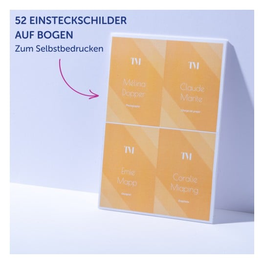 Bogen mit vier orangefarbenen Namensschildern im Visitenkartenstil, die an eine helle Wand gelehnt sind?