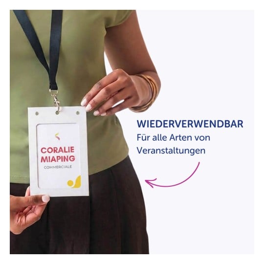 Oberkörper einer Person, die ein grünes Oberteil und ein schwarzes Schlüsselband trägt und einen weißen Ausweishalter hält?