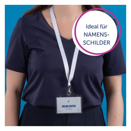 Das Bild zeigt eine Person, die ein marineblaues Hemd trägt, mit einem Namensschild, das an einem Umhängeband um den Hals hängt. Auf dem Namensschild steht 'MELINA DOPPER, Designerin' und es gibt eine kreisförmige Grafik, die auf Deutsch 'Ideal für NAMENS-SCHILDER' sagt.