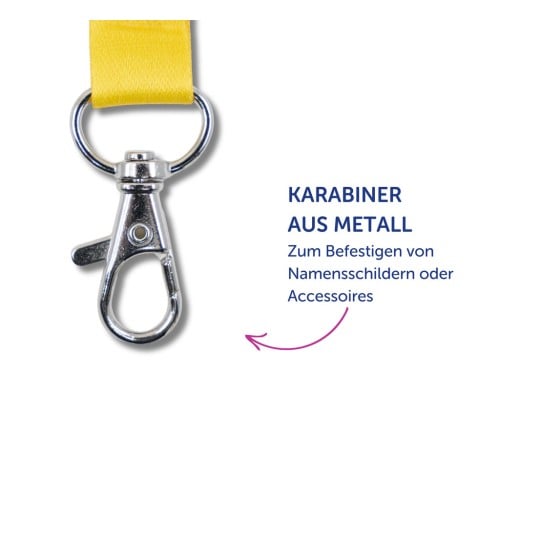 Das Bild zeigt einen metallischen Karabiner, der an einem gelben Riemen befestigt ist, mit einem deutschen Text, der seine Verwendung zur Befestigung von Namensschildern oder Zubehör erklärt.