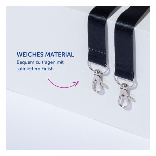 Das Bild zeigt zwei schwarze Riemen mit Metallclips, begleitet von dem deutschen Text 'Weiches Material' und 'Angenehm zu tragen mit Satin-Finish'.
