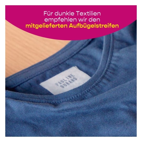 Das Bild zeigt eine Nahaufnahme eines blauen Stoffs in der Nähe eines Kleidungsetiketts mit der Aufschrift "PAULINE DURAND". Im Hintergrund befindet sich Text, der die Verwendung bestimmter Bügelstreifen für dunkle Textilien empfiehlt.