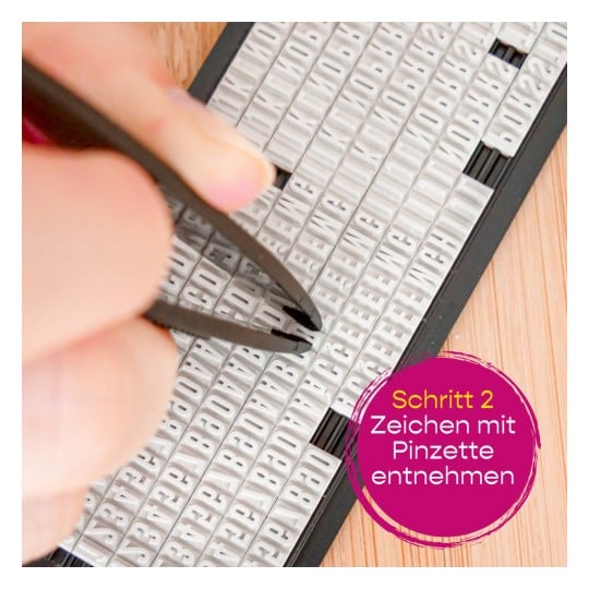 Das Bild zeigt eine Person, die mit einer Pinzette Buchstaben aus einem mit verschiedenen Buchstabenkacheln gefüllten Tablett aufnimmt. Der eingeblendete Text gibt an, dass es sich um Schritt zwei eines Prozesses handelt, bei dem Zeichen entfernt werden.
