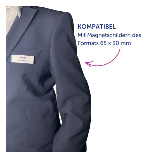 Das Bild zeigt eine Person in einem dunklen Anzug mit einem Namensschild, auf dem 'Avery Paul Meyer' steht. Rechts daneben befindet sich ein Text auf Deutsch, der 'KOMPATIBEL Mit Magnetschildern des Formats 65 x 30 mm' lautet und die Kompatibilität mit Magnetschildern einer bestimmten Größe angibt.