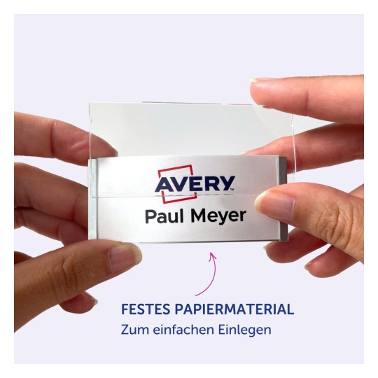 Das Bild zeigt eine Person, die einen Kartenhalter mit einem Namensschild darin hält, auf dem 'Avery Paul Meyer' steht. Der Hintergrund ist hellviolett, und es gibt eine Nachricht, die das robuste Material für einfaches Einfügen hervorhebt.