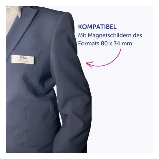 Das Bild zeigt eine Person in einem blauen Anzug mit einem Namensschild, auf dem „Paul Meyer“ und das Wort „KOMPATIBEL“ steht, was die Kompatibilität mit magnetischen Namensschildern der Größe 74 x 34 mm anzeigt.
