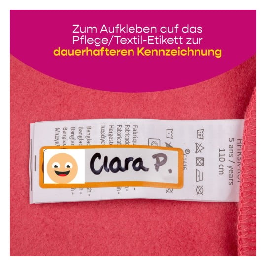 Das Bild zeigt einen rosafarbenen Stoffhintergrund mit einem Kleidungsetikett, das die Pflegehinweise deutlich zeigt. Auf dem Etikett steht der Name 'Clara P.'.