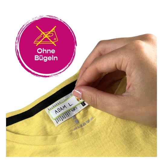 Das Bild zeigt eine Hand, die das Etikett eines gelben Kleidungsstücks hält, auf dem 'ADAM L.' steht und ein Symbol mit einem Bügelverbot abgebildet ist, bezeichnet mit 'Ohne Bügeln'.