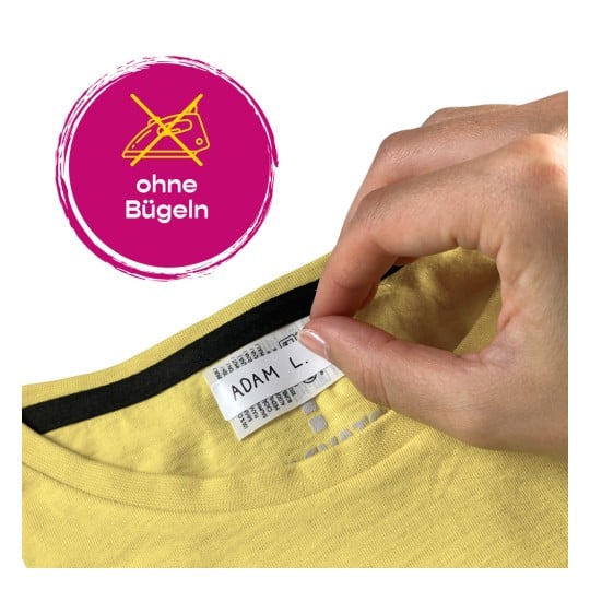 Eine Hand hält ein Bekleidungsetikett in einem gelben Hemd, mit einem Symbol, das Bügeln verbietet, und dem Text 'ohne Bügeln'.