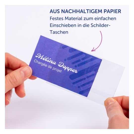Das Bild zeigt eine Hand, die eine Namenskarte aus nachhaltigem Papier hält. Die Karte hat einen blauen Hintergrund mit weißem Text, der den Namen 'Mélina Dopper' und den Titel 'Chargée de projet' anzeigt. Es gibt einen Hinweis auf ein stabilisierendes Material für die einfache Einfügung in Kartenhalter.