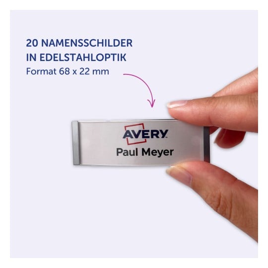 Das Bild zeigt eine Hand, die ein Namensschild mit dem Text 'Avery' und dem Namen 'Paul Meyer' hält. Es hebt 20 Namensschilder in Edelstahloptik hervor und erwähnt die Größe von 68 x 22 mm.