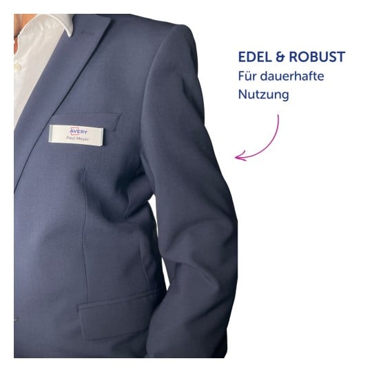 Das Bild zeigt eine Person in einem dunklen Anzug mit einem Namensschild, auf dem 'Paul Meyer' steht, und hebt ein Produkt mit dem Text 'EDEL & ROBUST Für dauerhafte Nutzung' hervor.