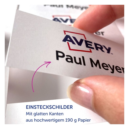 Das Bild zeigt eine Hand, die eine Karte mit dem Namen 'Paul Meyer' und dem Logo von 'Avery' hält. Es beschreibt die Karte als aus hochwertigem Papier gefertigt und mit einer glatten Kante ausgestattet.