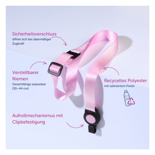 Das Bild zeigt einen rosa verstellbaren Riemen aus recyceltem Polyester, mit einem Sicherheits-Auslösemechanismus und einem Clip-Verschluss. Der Text hebt die verstellbare Länge und die verwendeten Materialien hervor.
