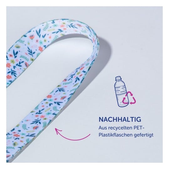 Das Bild zeigt ein buntes Band aus recycelten PET-Plastikflaschen mit Blumenmustern und einem Text, der auf Nachhaltigkeit hinweist. Es betont Umweltfreundlichkeit und Recycling.
